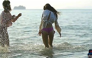 Lesbian Asian and European girlfriends playing in the ocean