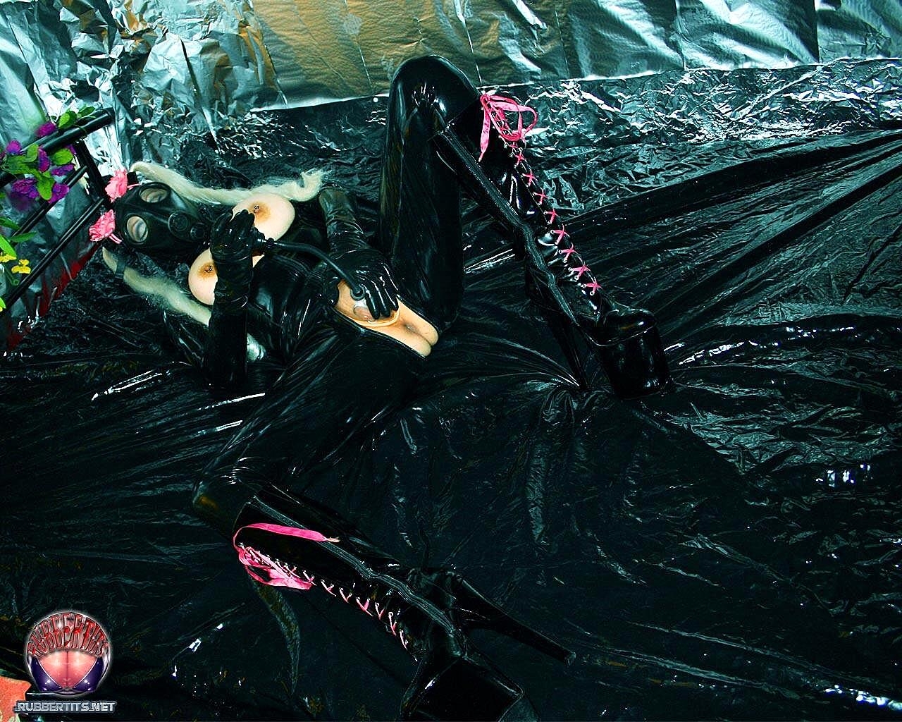 Latex clad chick with pierced nipples pumps up her pierced pussy in boots