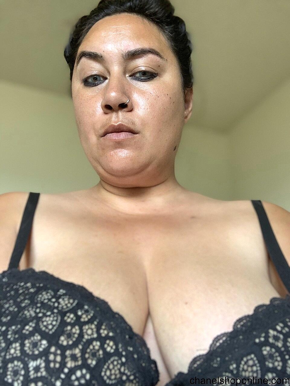 Angry mature woman poses in her bra and shows her sexy cleavage